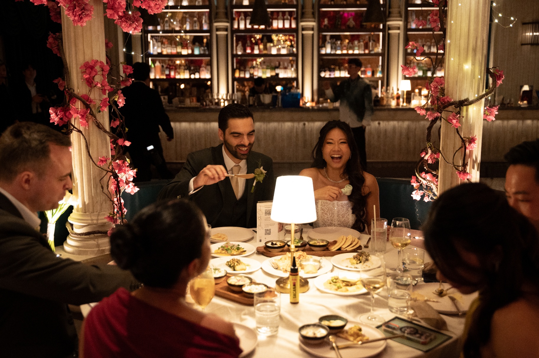 Guests dining and laughing at a candlelit table at Aesops
