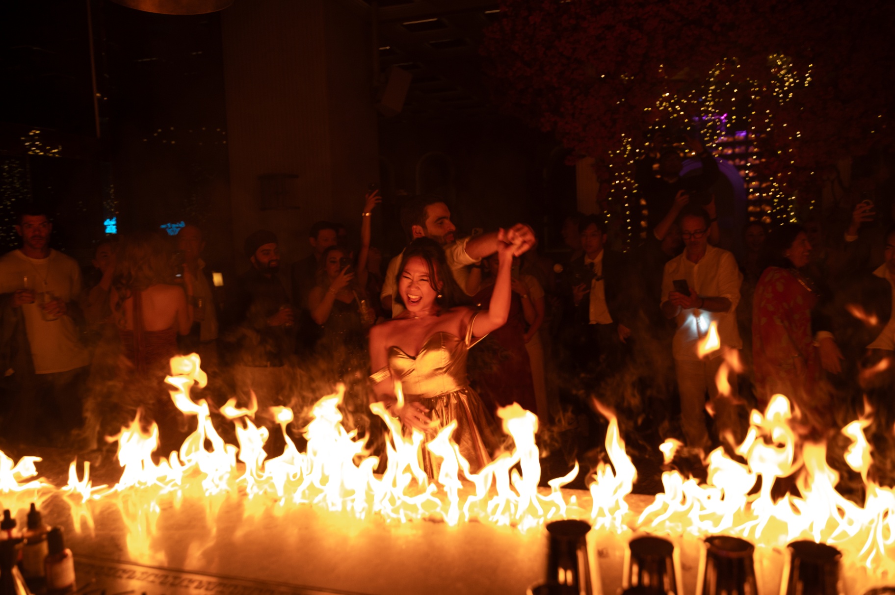 Guest dancing behind a wall of fire at Aesops