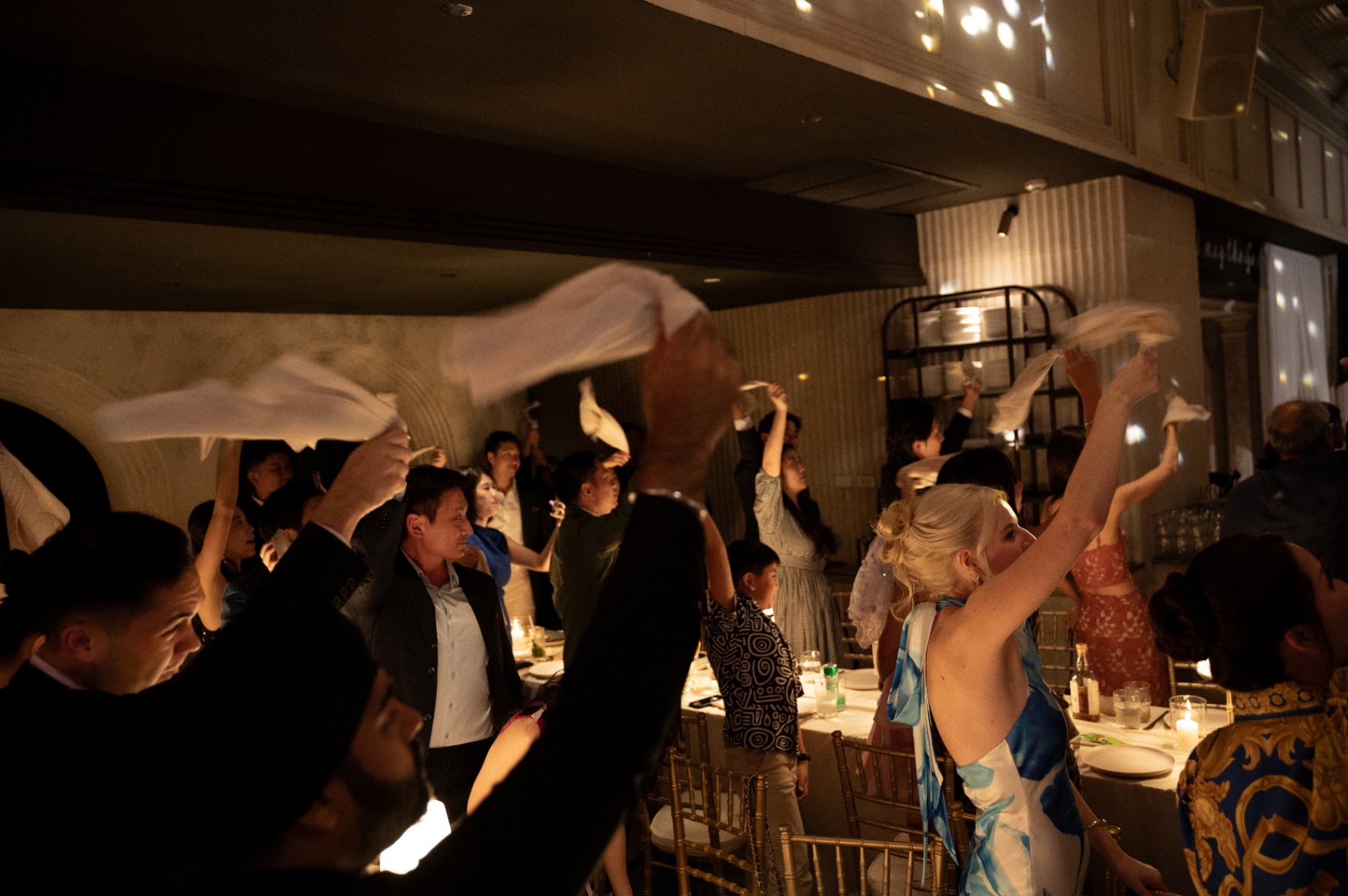 Guests waving white napkins in the air at Aesops